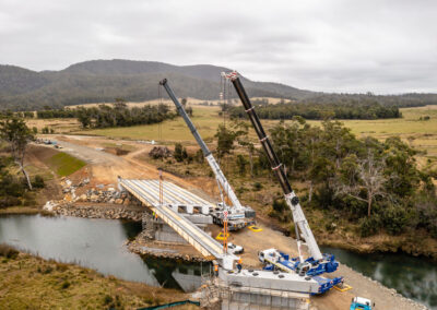 Aerial view of dual crane lift of bridge span